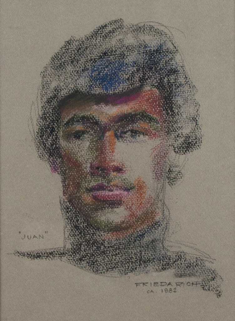 Portrait of young Latino man wearing a black turtleneck. He has black hair and a faint mustache.