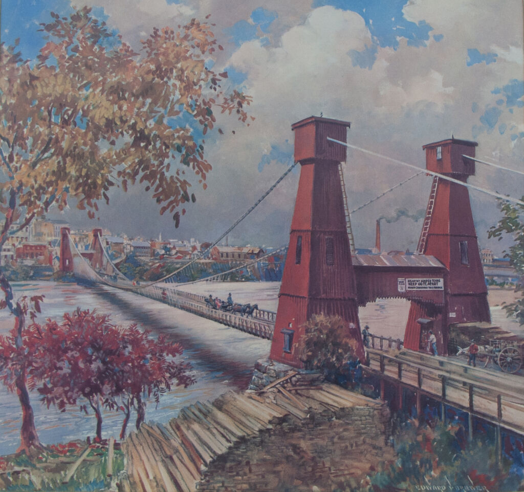 Print of a red suspension bridge crossing the Mississippi. A pile of logs is in the foreground, beside trees with red and yellow leaves. Framed with brown wood.