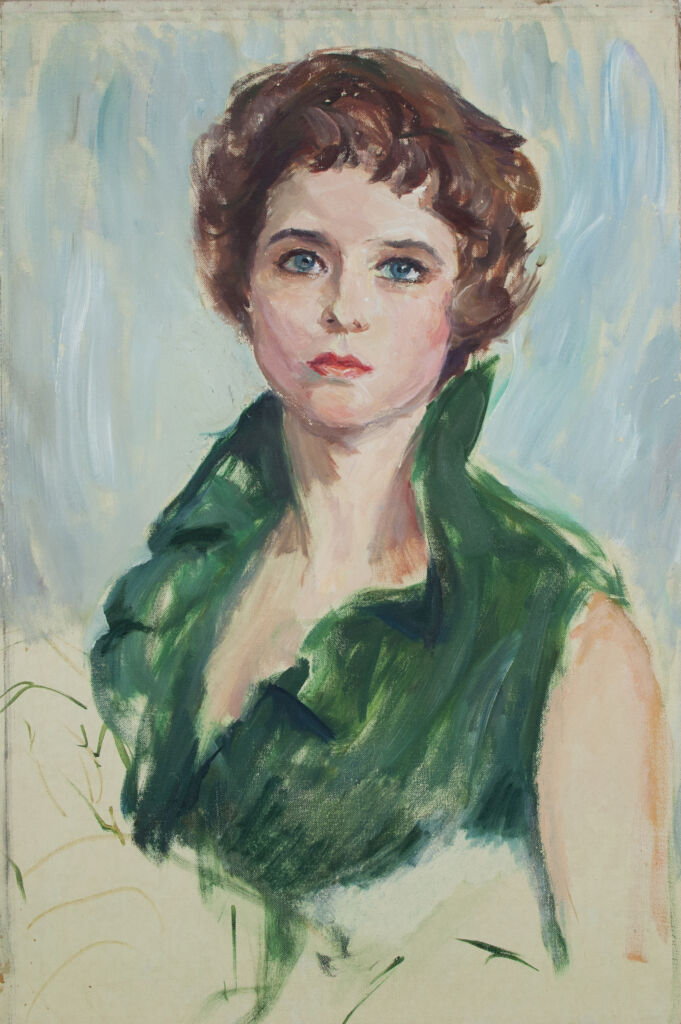 Portrait of white woman in her twenties. She has brown hair, blue eyes, and is wearing a short-sleeve green dress.