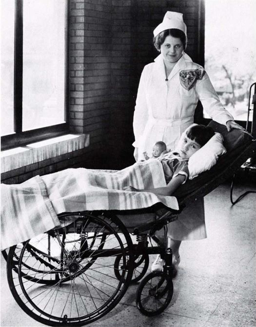 A nurse with a child in a wheelchair