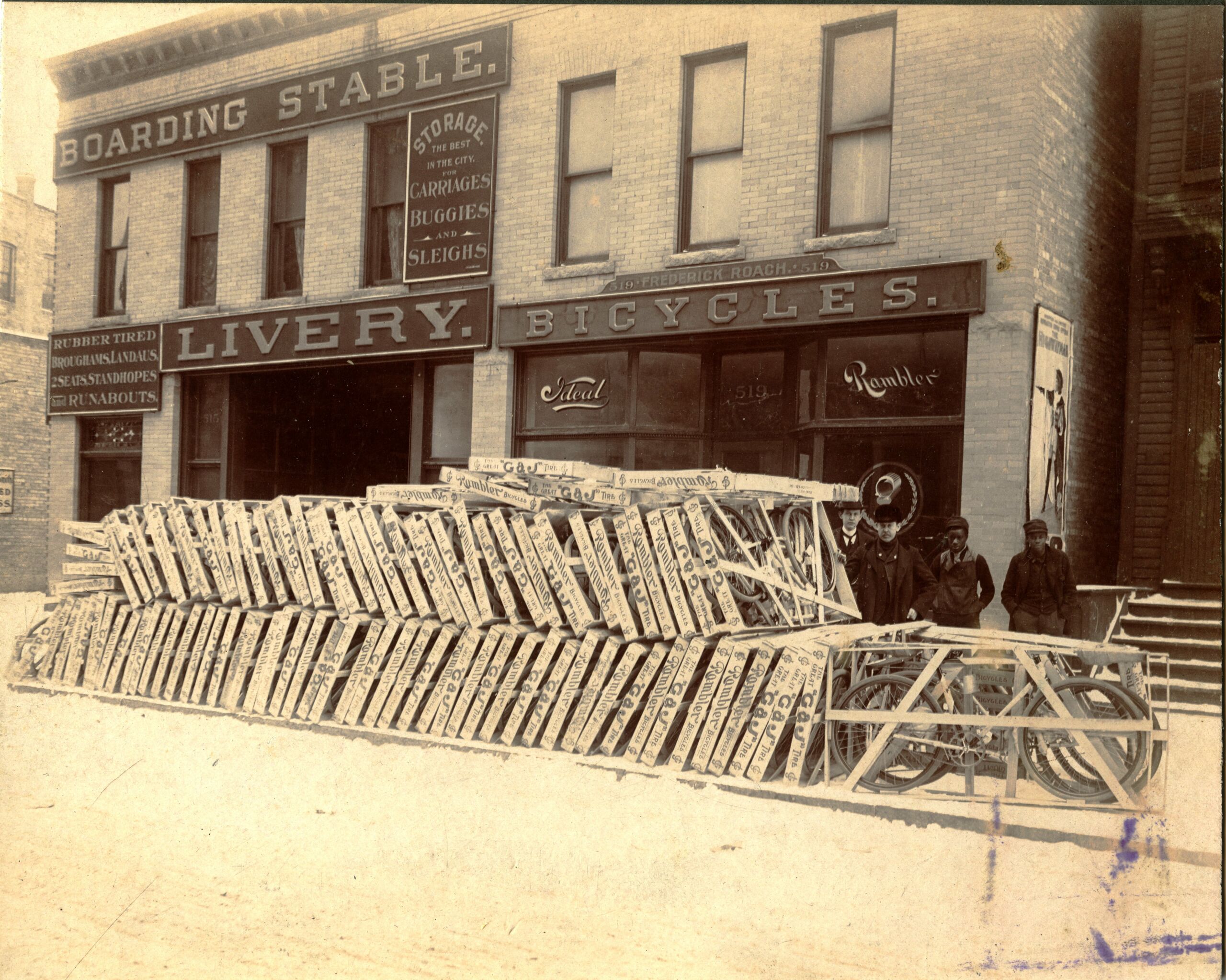 Frederick Roach Bike shop exterior and bicycles in crates. 4 people in photo.